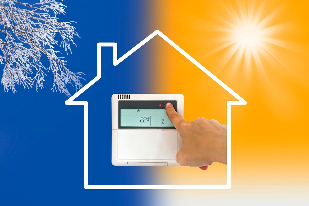 Hand adjusting a thermostat in a house with winter and sunny weather contrast.